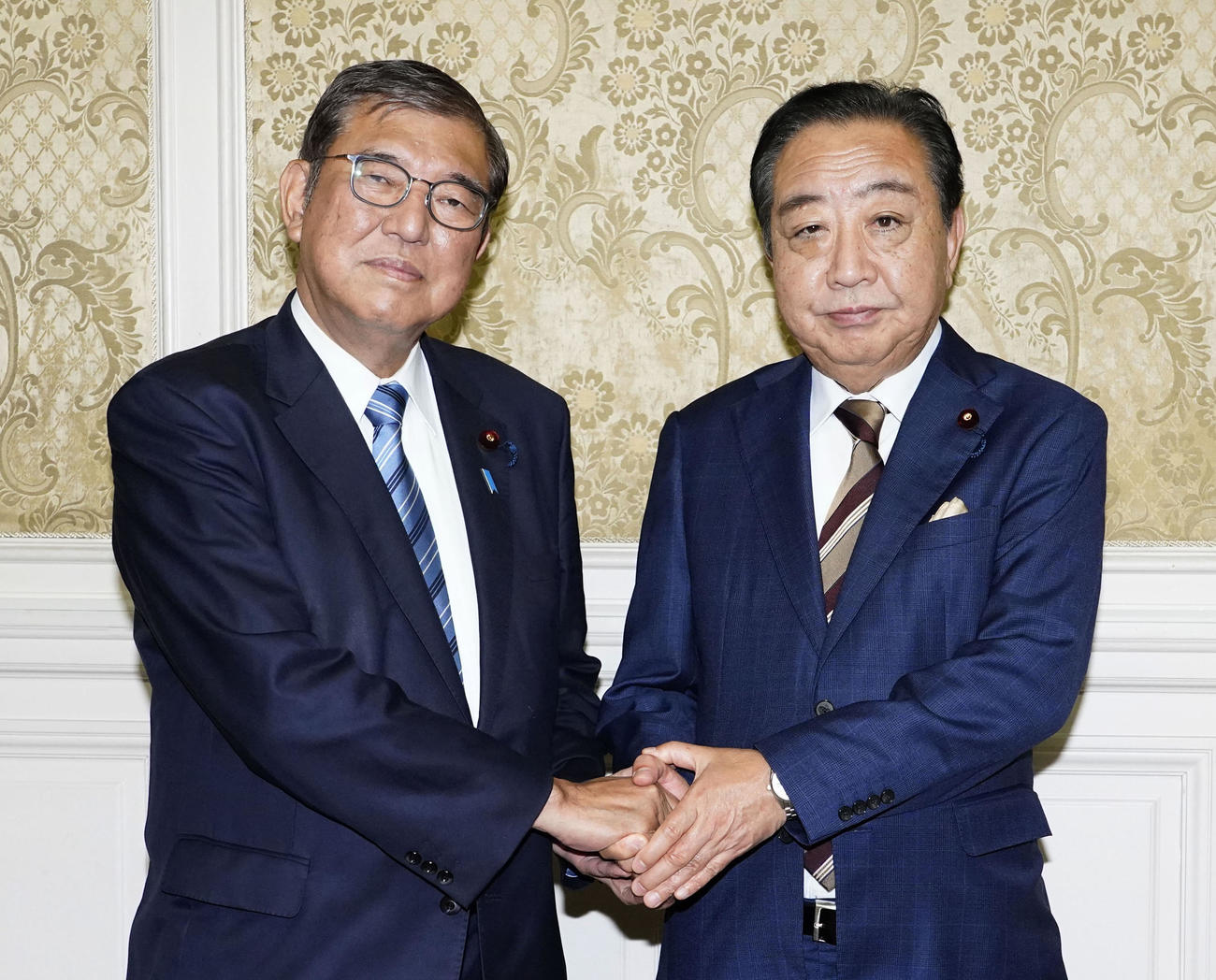 立憲民主党へのあいさつ回りで野田佳彦代表（右）と握手する石破茂首相（共同）