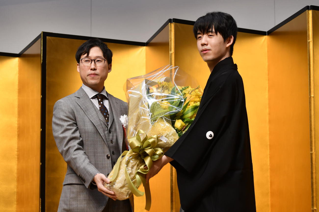 祝福に駆けつけた囲碁の井山裕太王座（碁聖・十段＝左）から花束を贈呈された藤井聡太王位（右）。2人合わせて10冠の豪華なツーショットが実現