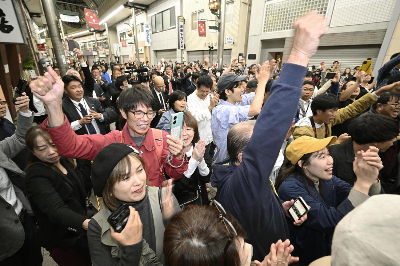 兵庫県知事選で、斎藤元彦氏の再選を伝える速報に喜ぶ支持者ら（共同）