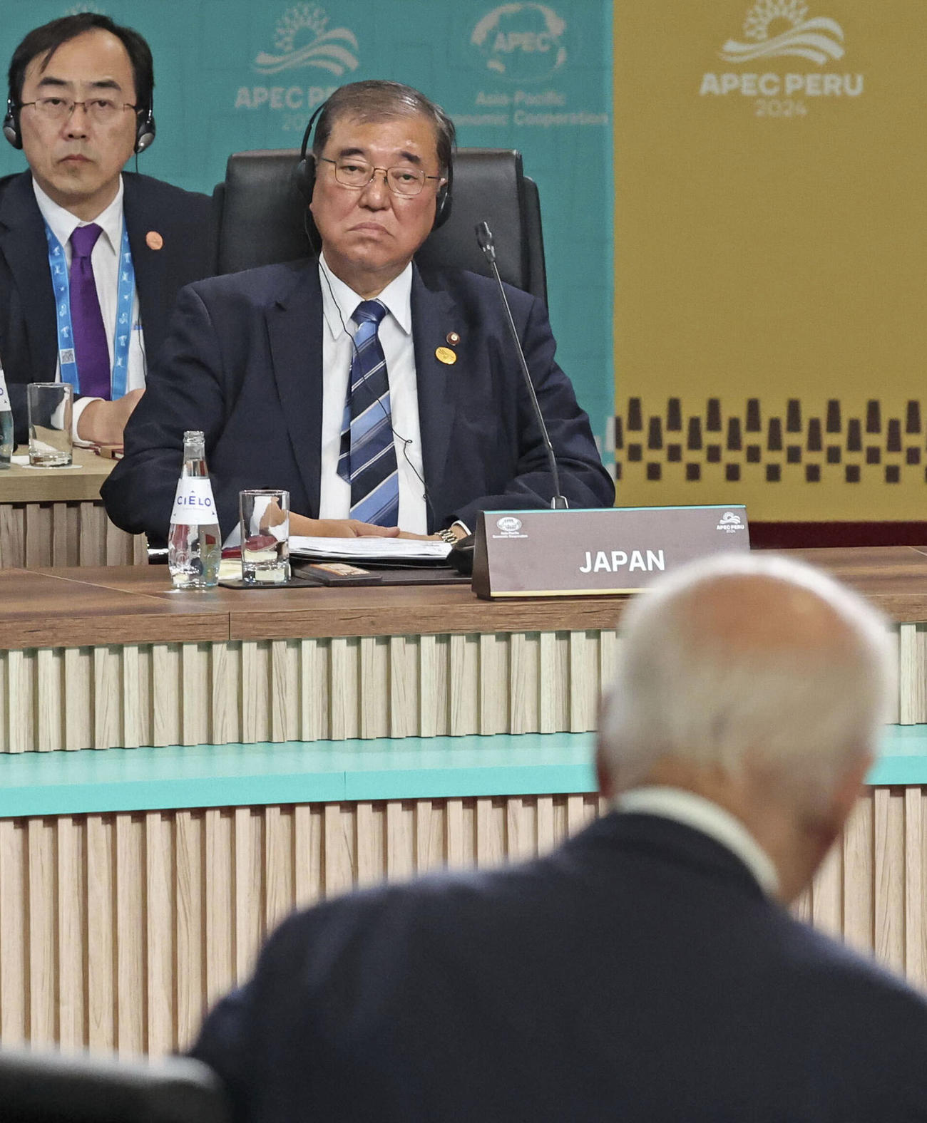 APEC首脳会議の初日討議でバイデン米大統領（手前）を見つめる石破首相＝15日、ペルー・リマ（代表撮影・共同）