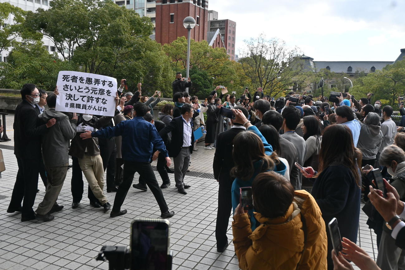 斎藤元彦知事の初登庁時には抗議の紙を掲げる人も（撮影・松浦隆司）