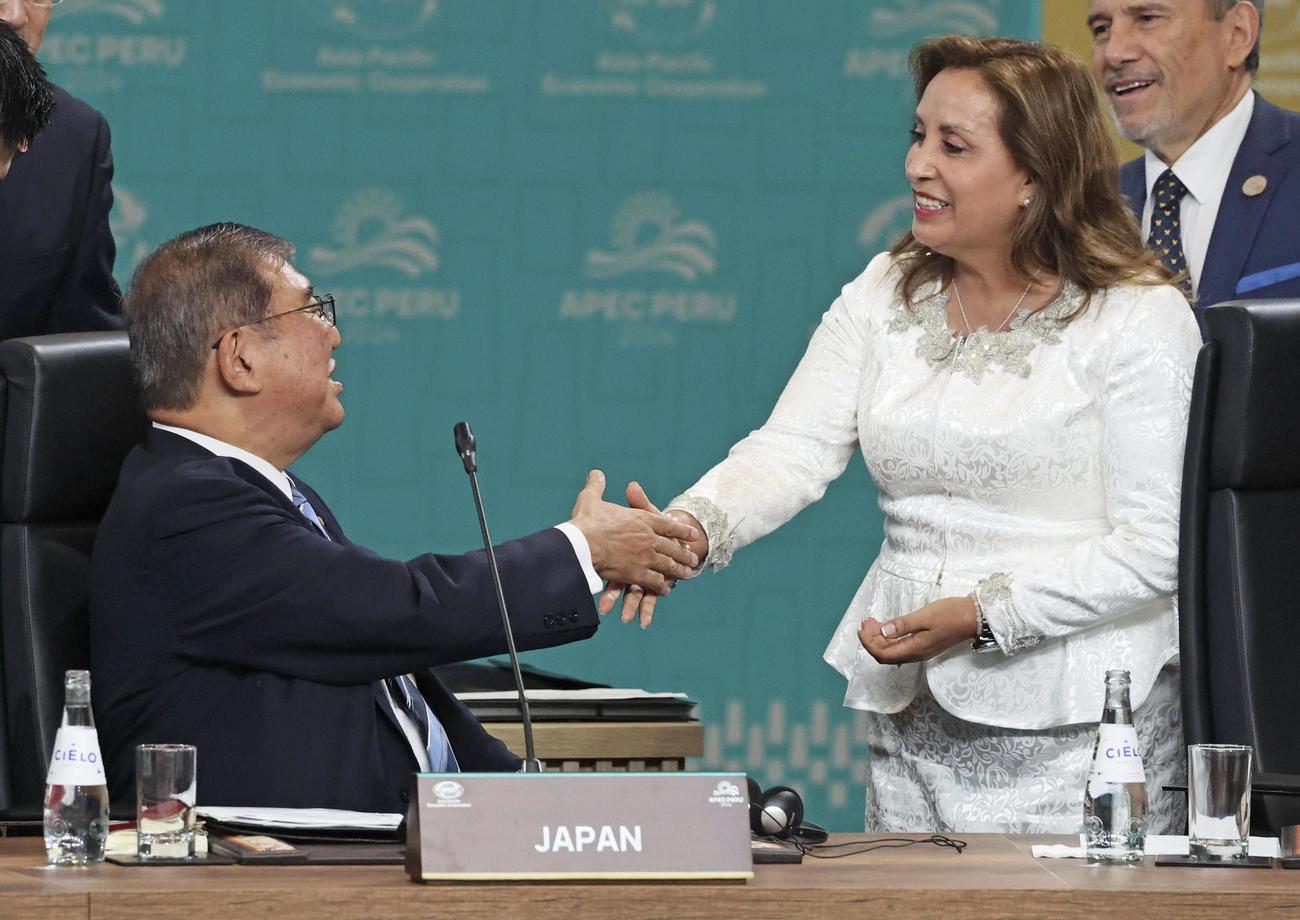 15日、APEC首脳会議の初日討議を前に、ペルーのボルアルテ大統領（右）と言葉を交わす石破首相（代表撮影・共同）