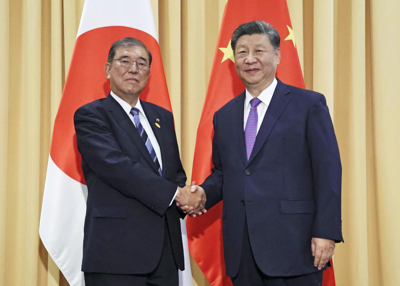 首脳会談を前に握手する石破首相（左）と中国の習近平国家主席（代表撮影・共同）
