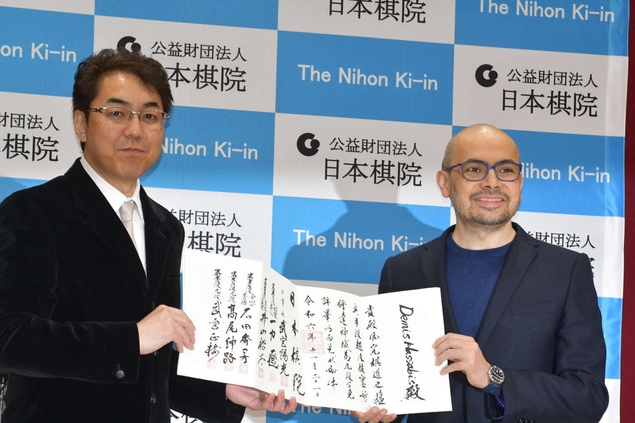 日本棋院の武宮陽光理事長（左）から九段の免状を贈呈されたノーベル化学賞受賞者のデミス・ハサビス氏（右）