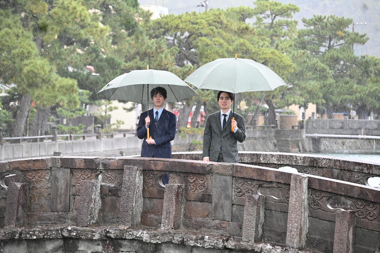 激しい雨と風の中、和歌の浦の「不老橋」から干潟を眺める藤井聡太竜王（左）佐々木勇気八段（撮影・松浦隆司）