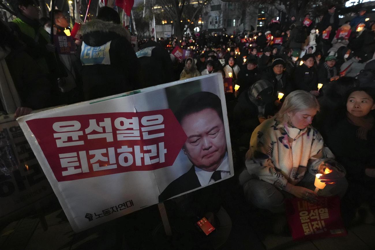 4日、韓国の尹錫悦大統領の辞任を求め、ろうそくをともす人々＝ソウル（AP＝共同）