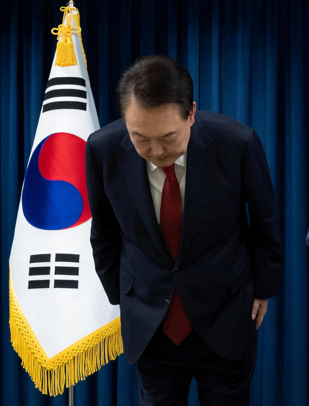 韓国・ソウルの大統領府で国民に向けて演説しながら頭を下げる韓国の尹錫悦大統領（ロイター）
