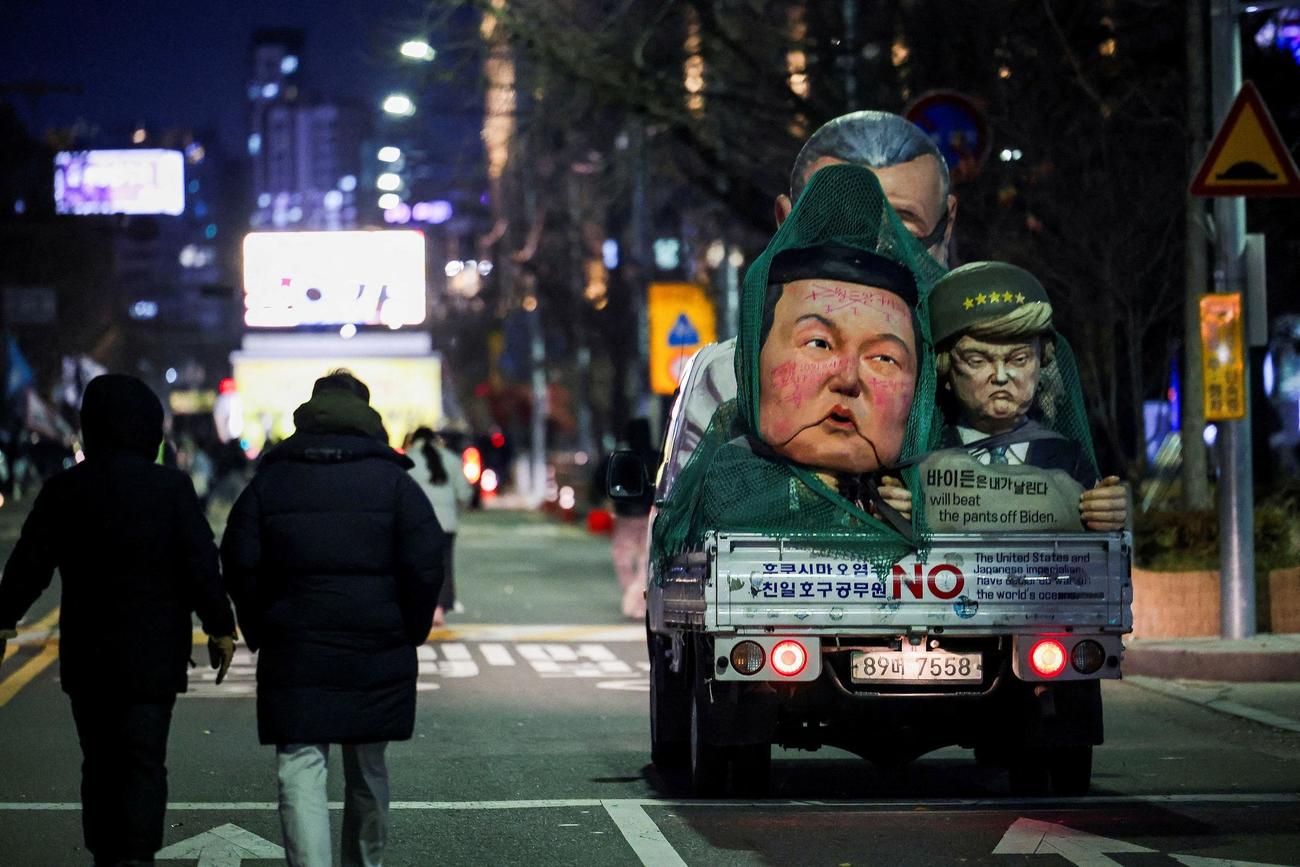 
2024年12月7日、韓国・ソウルの国会前で戒厳令を発令した韓国大統領の弾劾を求め、人形の近くを歩く人々（ロイター）