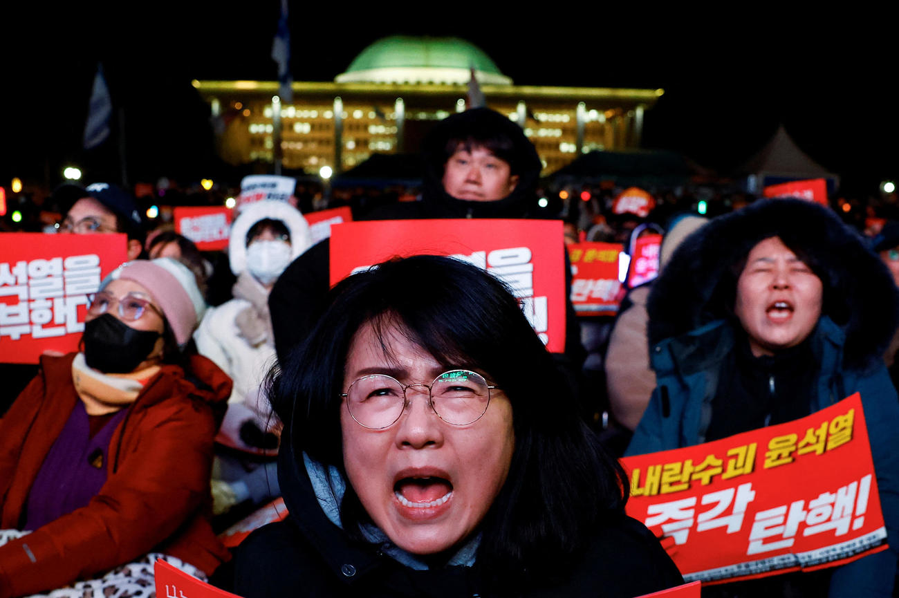 2024年12月7日、韓国・ソウルの国会前で戒厳令を発令した韓国大統領の弾劾を求める集会に参加し、スローガンを唱える抗議者たち（ロイター）