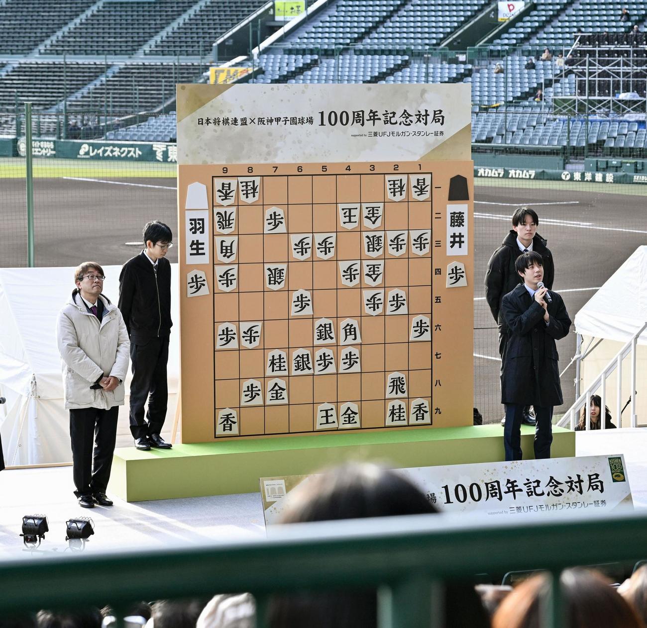 甲子園球場で記念対局を振り返る藤井聡太七冠（手前右）と羽生善治九段（同左）（共同）