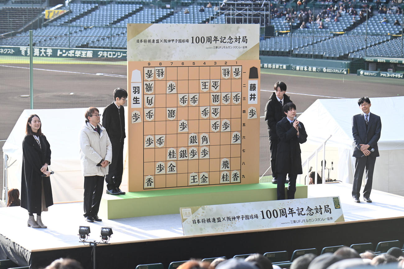 甲子園球場の三塁側スタンドで行われた感想戦で、あいさつする藤井七冠（前列右から2人目）（撮影・滝沢美穂子）