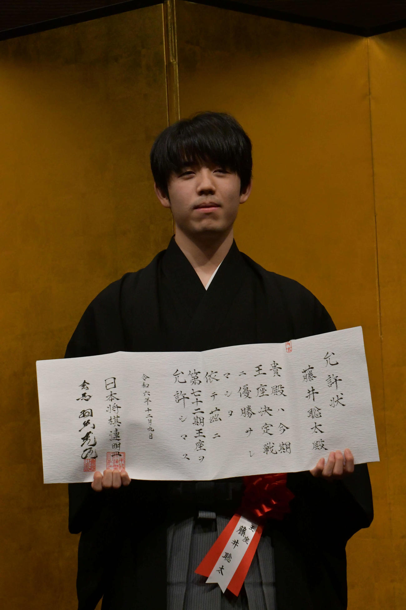就位式で允許（いんきょ）状を手にする藤井聡太王座