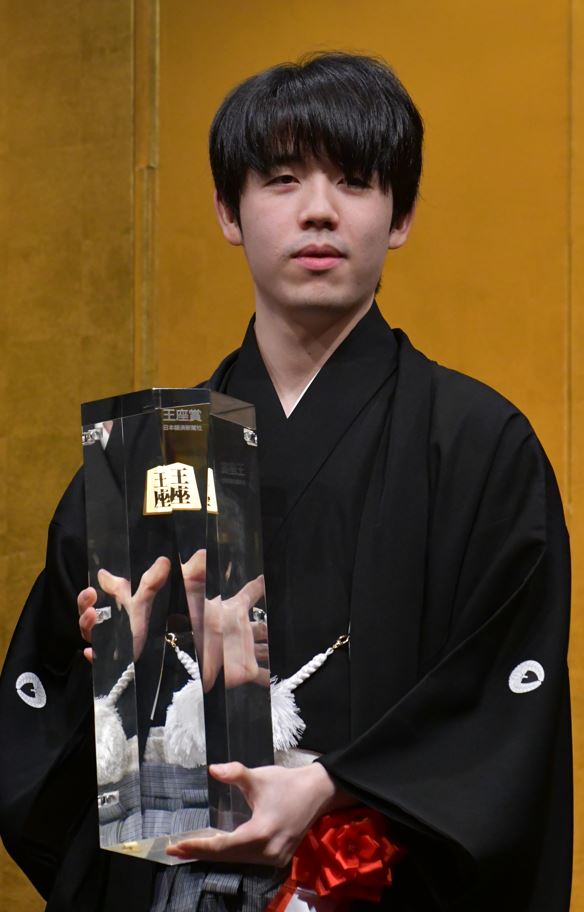 重さ7キロの王座賞トロフィーを手に持つ藤井聡太王座