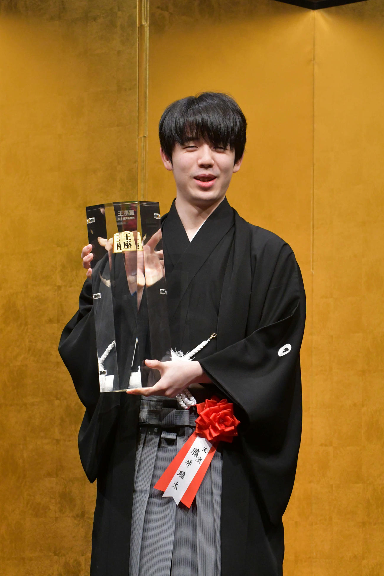 重さ7キロの王座賞トロフィーを手に持つ藤井聡太王座