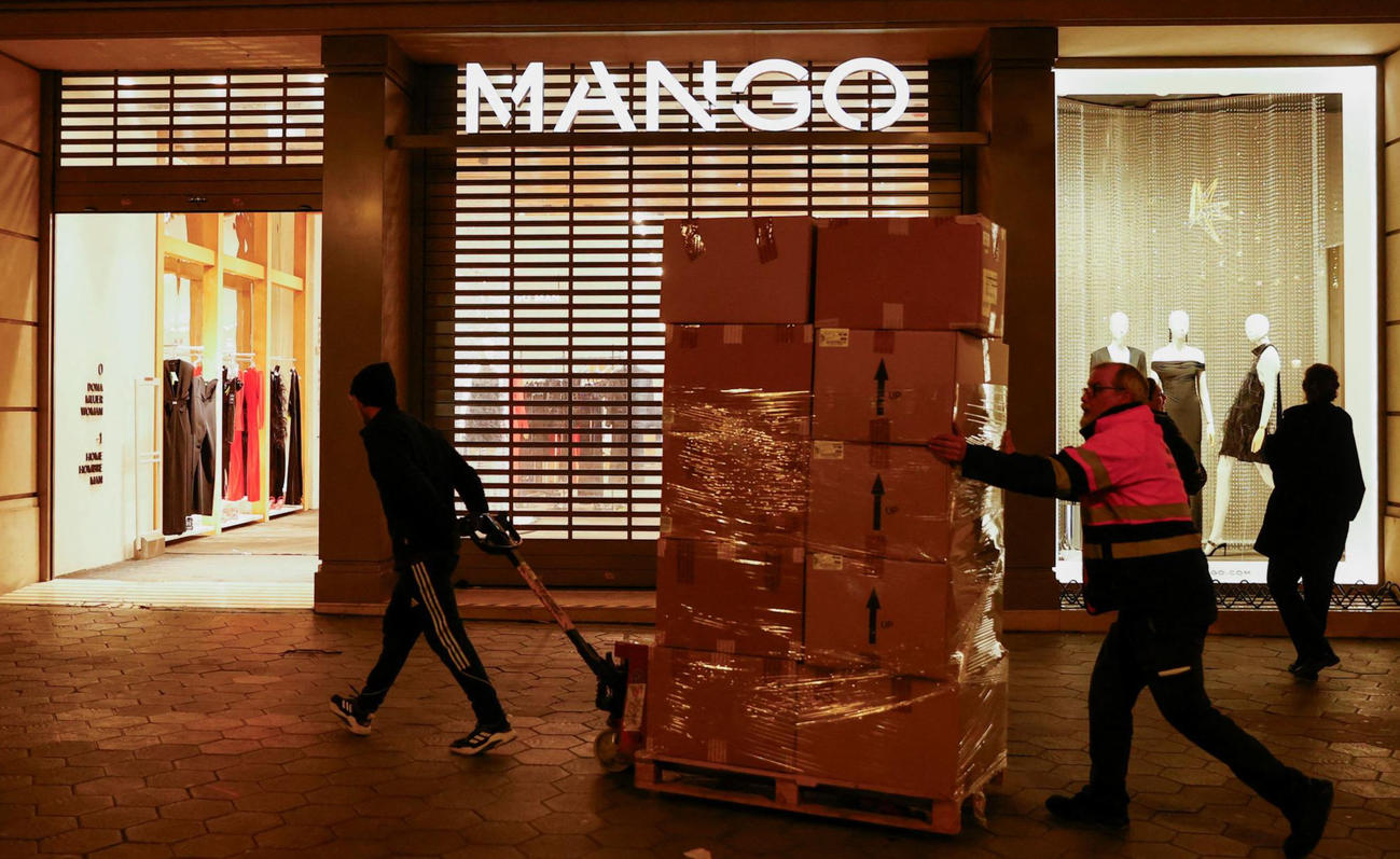 MANGOの創設者アイザック・アンディック氏が土曜日に亡くなった後、グラシア通りのマンゴー店で衣類の箱を並べる労働者たち（ロイター）