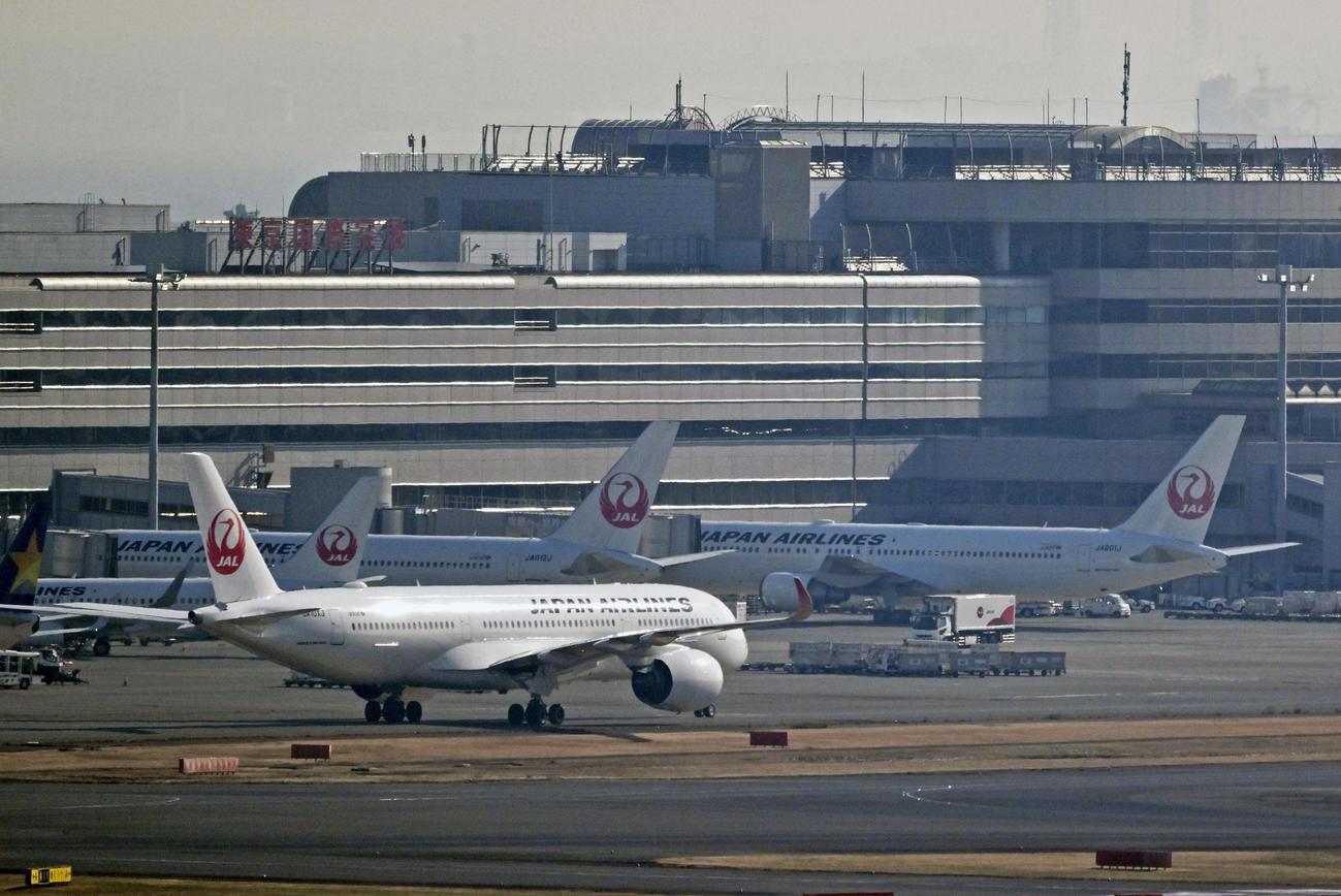 羽田空港のスポットに並ぶ日航機。システムの不具合が起き、一部の便に遅れが出た（共同通信社ヘリから）