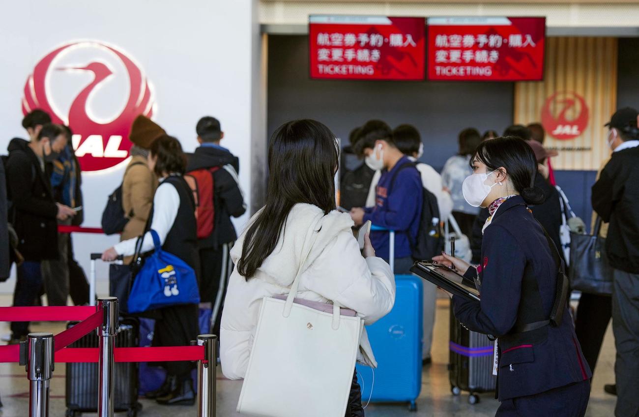 大阪空港で対応する日航のスタッフ（手前右）。システムなどに不具合が起きたと発表した＝26日午後0時22分（共同）