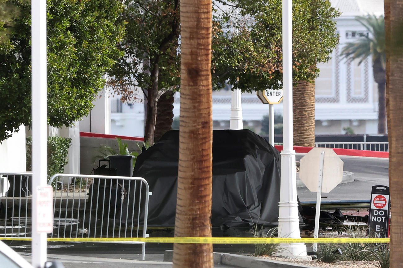 米ネバダ州ラスベガスのトランプタワーの玄関前で炎上したテスラ車。残骸にカバーが掛けられていた（２０２５年１月１日、ロイター）