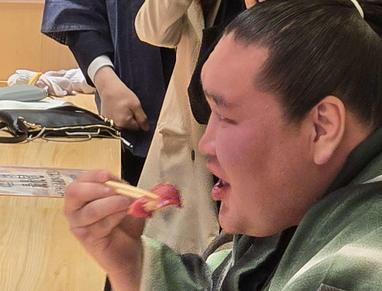 横綱照ノ富士は初競りで一番マグロとなったトロの部分を持って笑顔を見せた（撮影・寺沢卓）