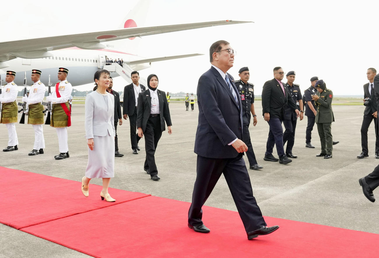 マレーシアのクアラルンプール国際空港に到着した石破首相。左は妻の佳子さん＝9日（共同）