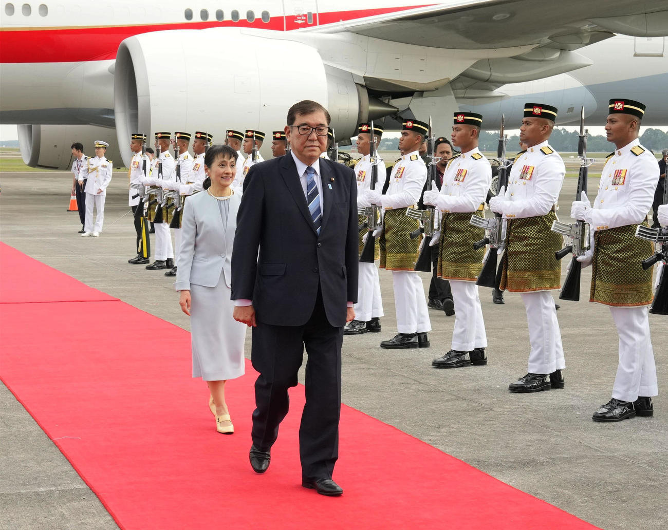 マレーシアのクアラルンプール国際空港に到着した石破首相。左奥は妻の佳子さん＝9日（共同）