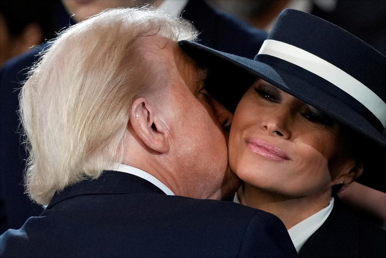 20日、ワシントンの米連邦議会議事堂で開かれた就任式で妻メラニアさん（右）にキスするトランプ大統領（ロイター＝共同）