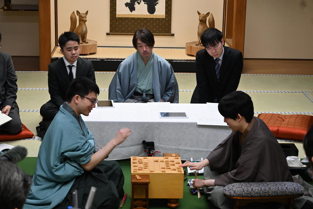 床の間に鎮座する一対の「おいなりさん」が見守る中、感想戦を行う永瀬拓矢九段（左）藤井聡太王将（撮影・松浦隆司）