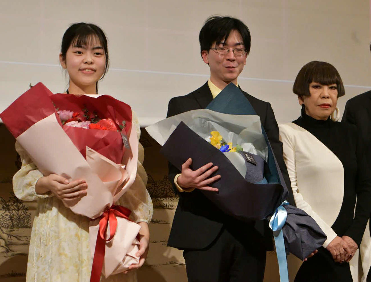 「ゆうきゅう戦　コシノジュンコ　クリスタルCUP」でペア碁を制した上野梨紗女流棋聖（左）と芝野虎丸九段。右はコシノジュンコ