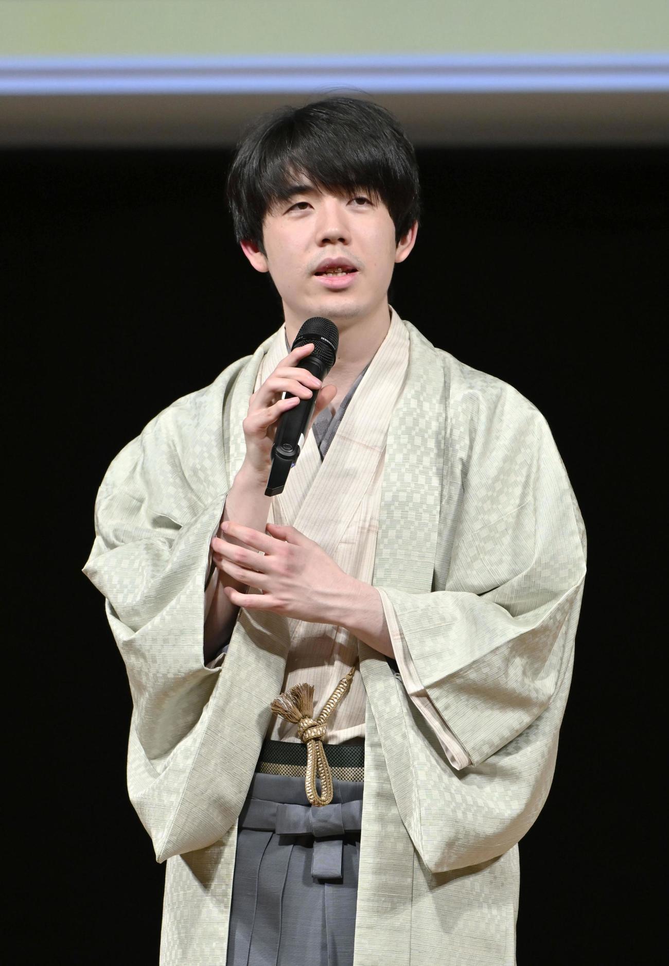 将棋の第50期棋王戦コナミグループ杯5番勝負第1局で勝利し、大盤解説会場であいさつする藤井聡太棋王（共同）