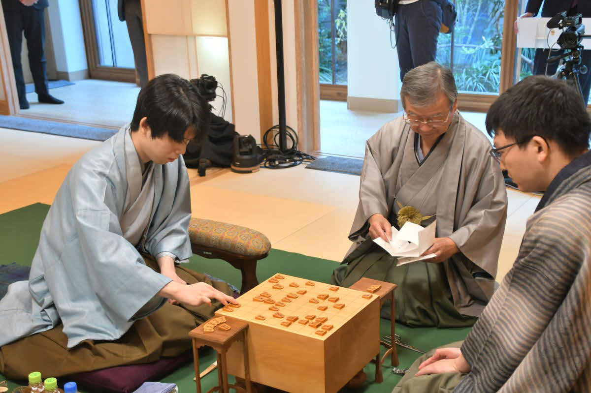 藤井聡太王将（左）が初日に封じた指し手を立会人の青野照市九段が開封して王将戦第3局は2日目が再開された（右は挑戦者の永瀬拓矢九段、日本将棋連盟提供）