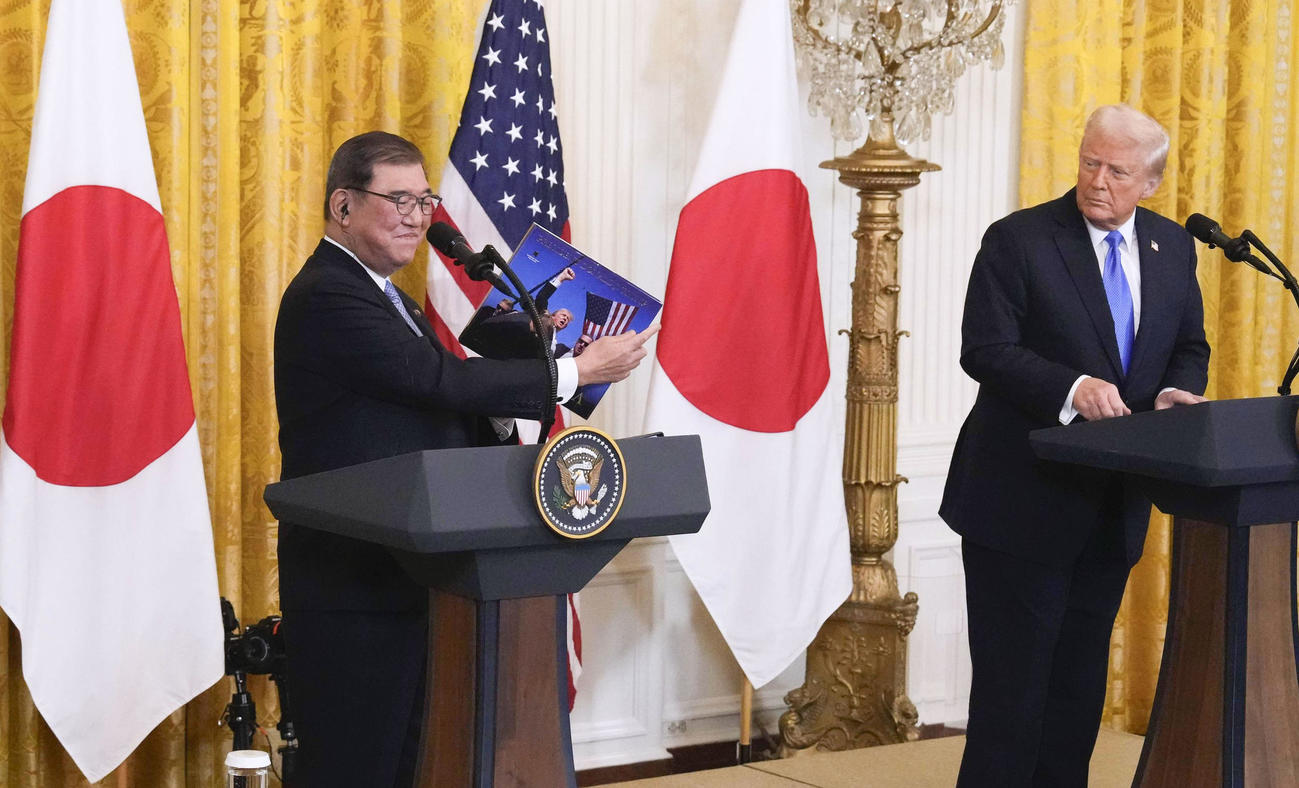 首脳会談後の共同記者会見で、トランプ米大統領（右）から写真を贈られ、笑顔を見せる石破首相＝7日、ワシントンのホワイトハウス（共同）