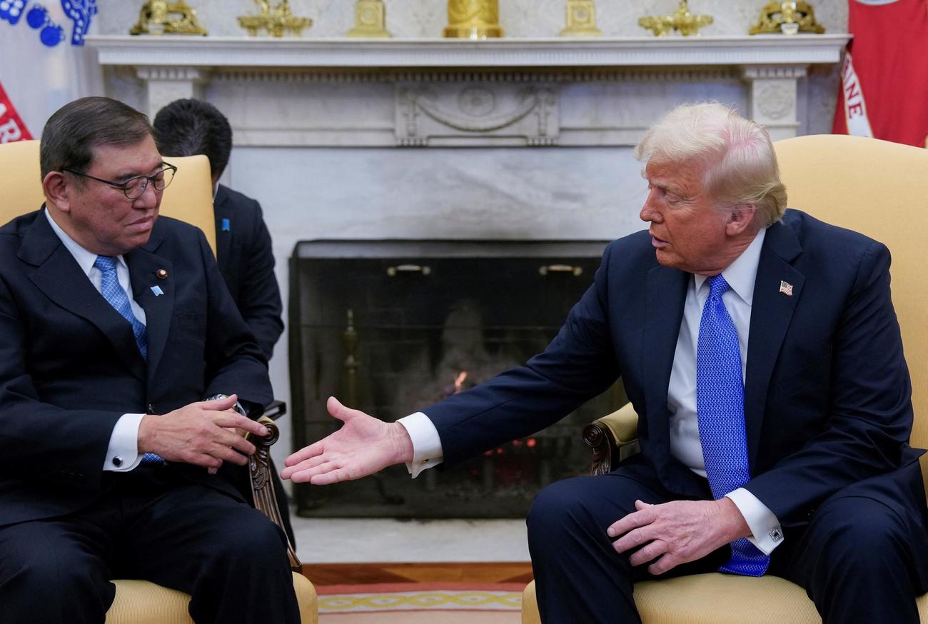 ホワイトハウスで石破茂首相に握手を求め、手を差し出すドナルド・トランプ大統領（２０２５年２月７日、ロイター）