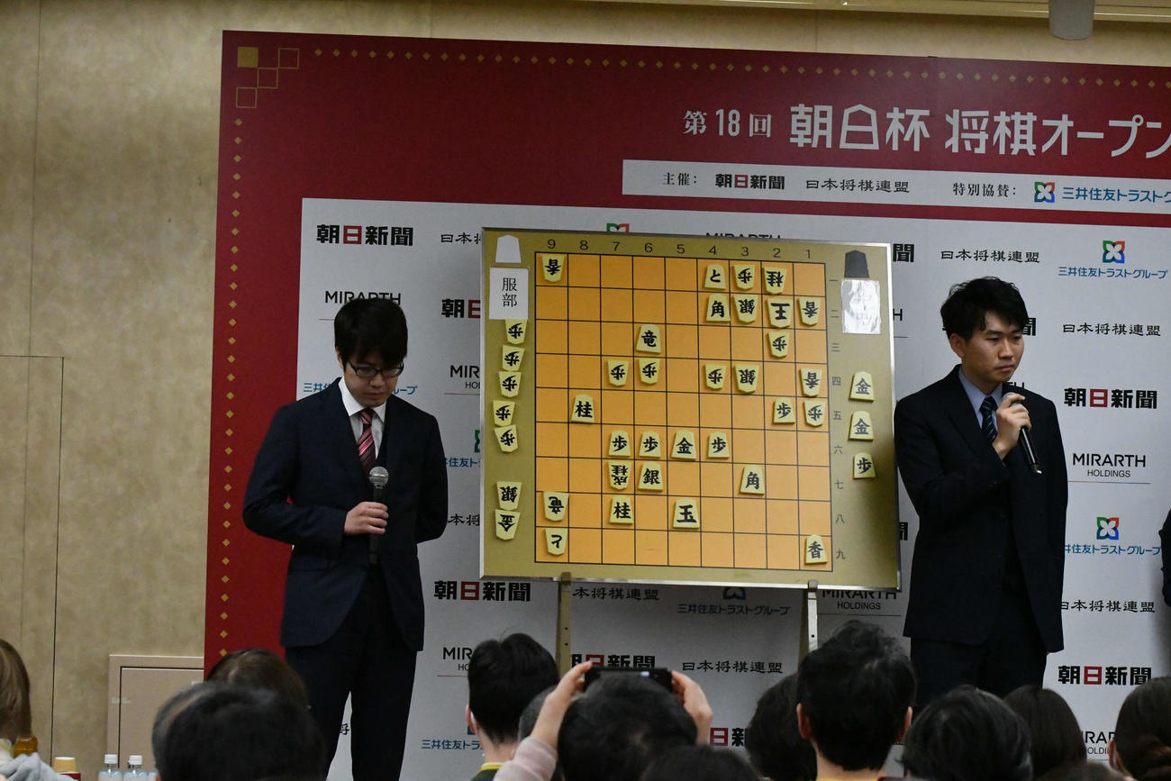 悔しさをかみしめてうつむく服部慎一郎七段（左）の横で対局を振り返る井田明宏五段（右）