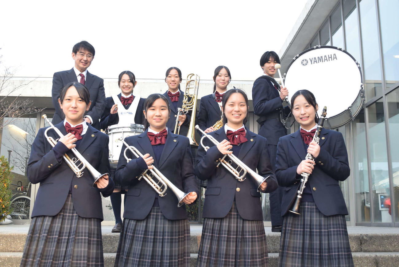 ブラスエキスポを楽しみに待つ箕面自由学園吹奏楽部の、前列左から明石実歩さん、梶原柚憂さん、谷村彩花さん、春山ゆいさん、後列左から福里大輔顧問、山岡若葉さん、山本初音さん、西谷芙唯さん、山下桐空さん（撮影・阪口孝志）