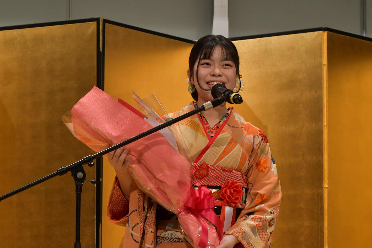 花束を手に謝辞を述べる上野梨紗女流棋聖