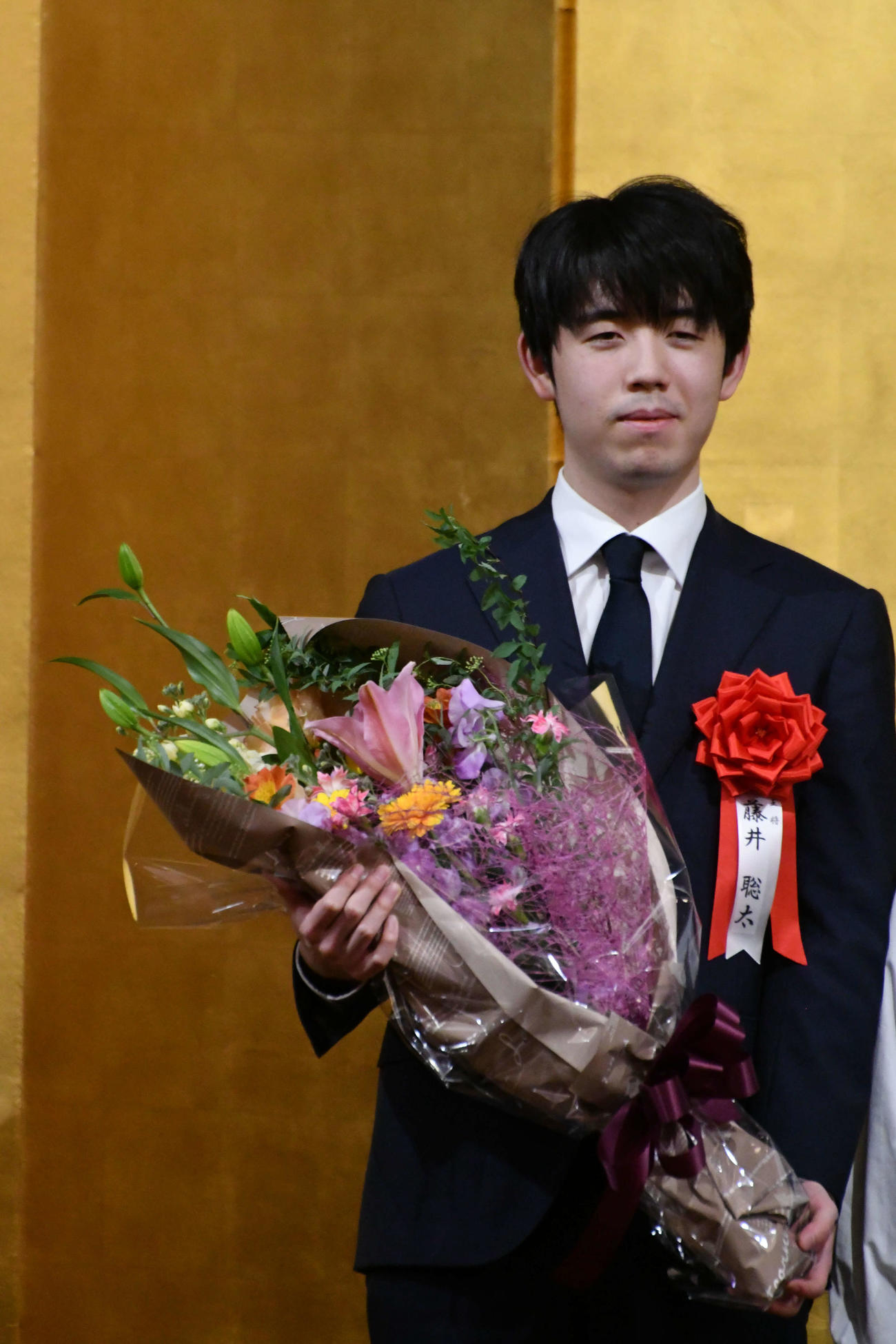 王将戦第5局前夜祭で花束を手にする藤井聡太王将