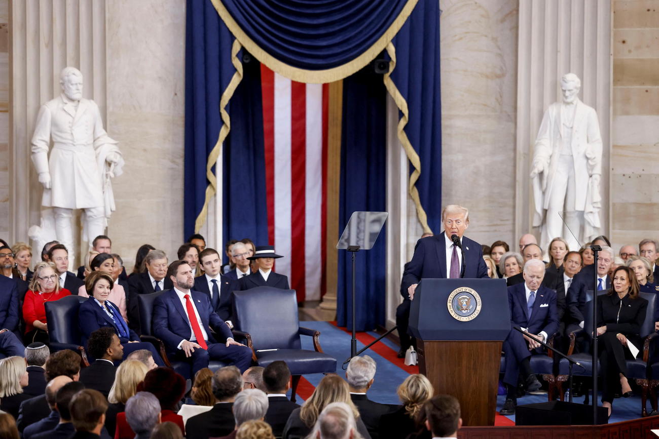 トランプ第47代大統領就任式　演説するドナルド・トランプ大統領（中央）左後方はメラニア夫人、右後方はバイデン前大統領、カマラ・ハリス氏が着席している（ロイター）