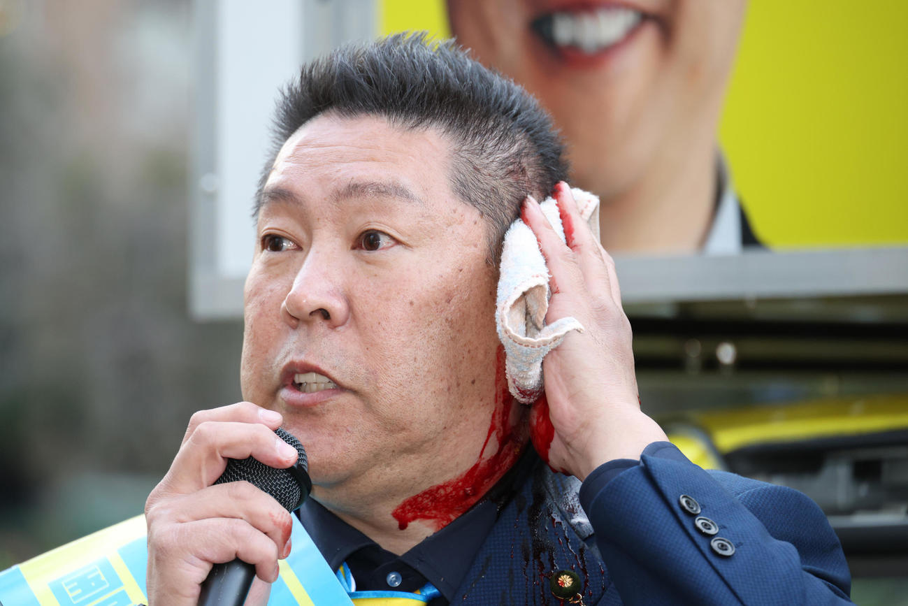 路上で暴漢に襲われ出血した状態でマイクで襲われた状況などを話す立花孝志氏（撮影・中島郁夫）