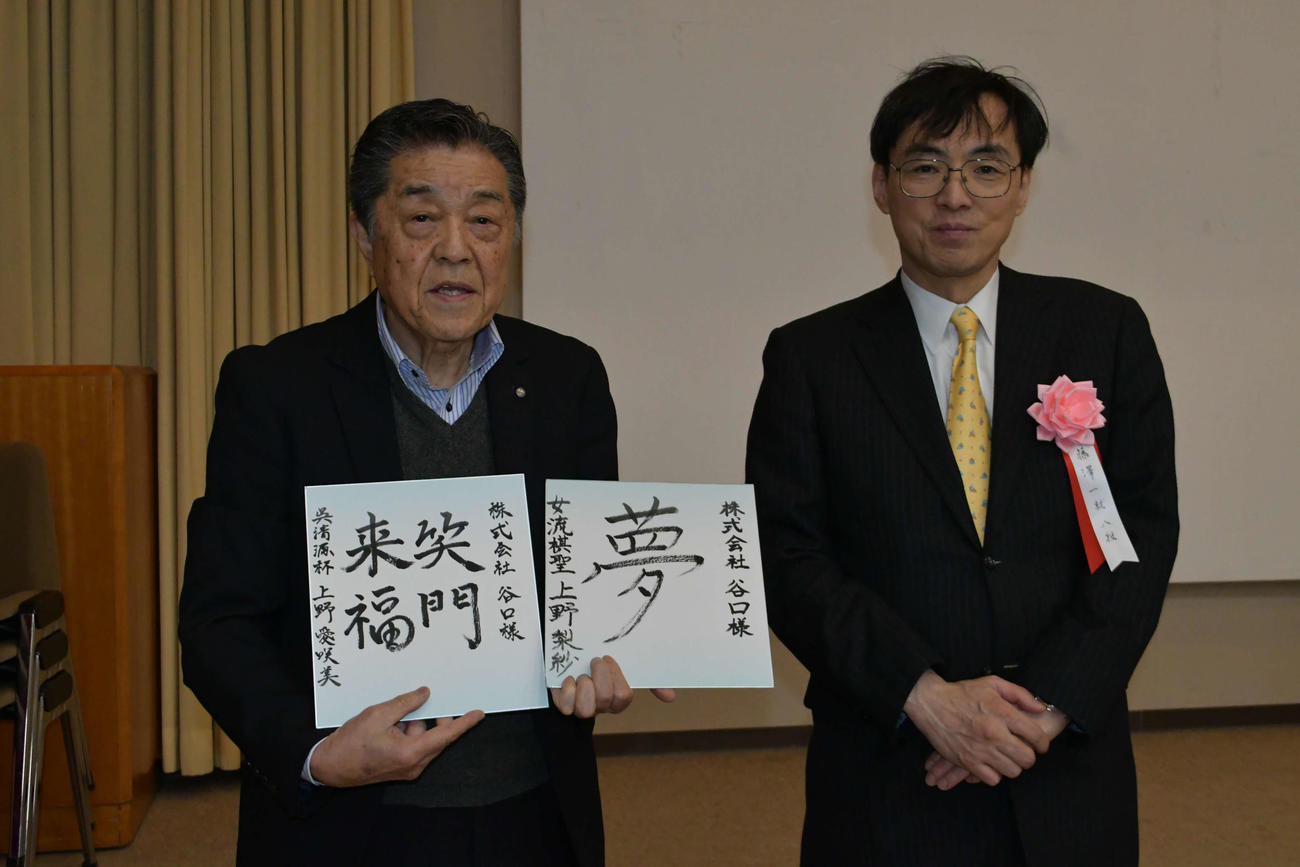 贈呈された色紙を手にする谷口正晴社長（左）と藤澤一就八段（右）