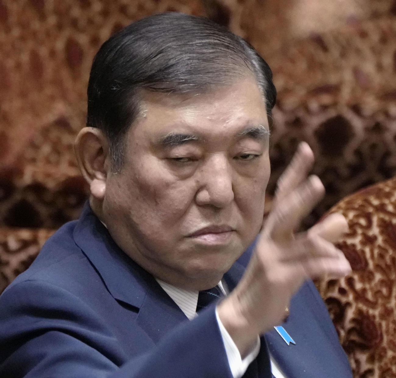 参院予算委の集中審議で答弁のため手を挙げる石破首相＝19日午前