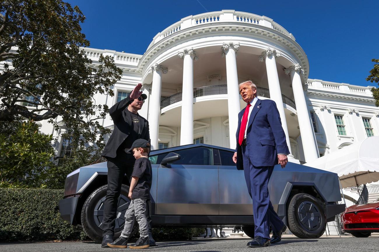 ホワイトハウスで、マスク氏（左）のとなりでメディアに語りかけるトランプ大統領。マスク氏の後の車はテスラの「サイバートラック」（2025年3月12日、ロイター）