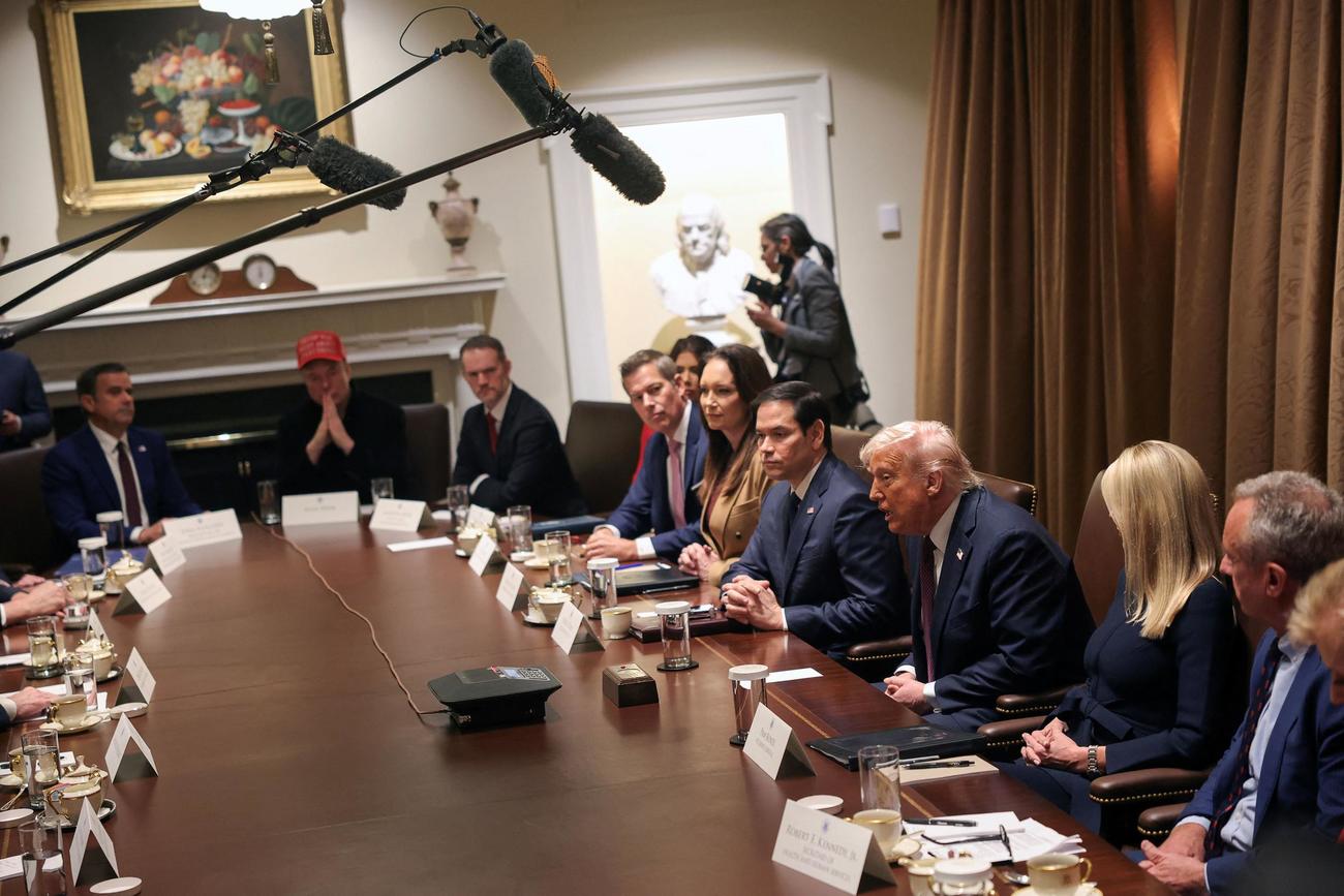 「トランプ氏は全てにおいて正しかった」と刺しゅうされた赤い帽子をかぶり、閣議で中央の長机の閣僚たちと肩を並べる待遇を受けたマスク氏（左から２人目）トランプ大統領は右から３人目（２０２５年３月２４日、ロイター）