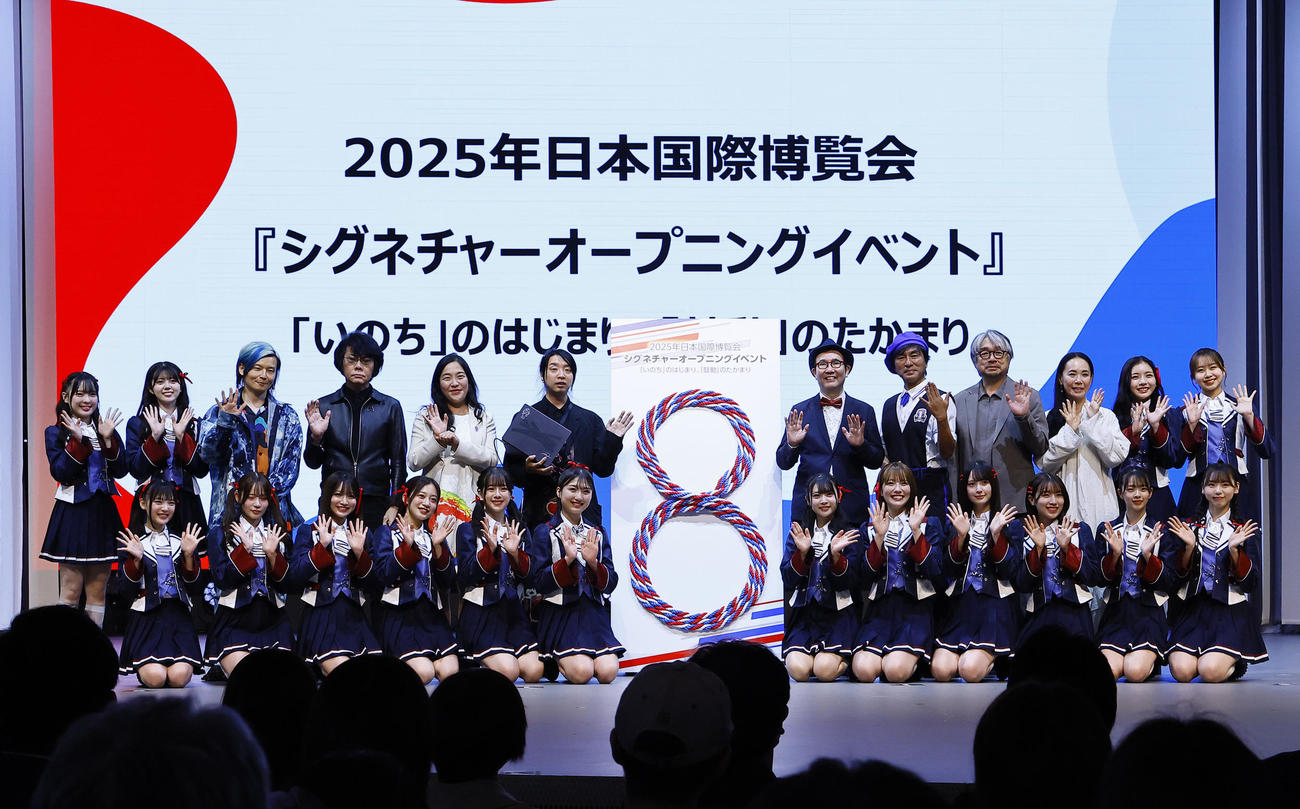 大阪・関西万博のシグネチャーオープニングイベントでポーズをとる（後列左3人目から）宮田裕章氏、石黒浩氏、中島ちさこ氏、落合陽一氏、福岡伸一氏、河森正治氏、小山薫堂氏、河瀬直美氏とNMB48（撮影・藤尾明華）