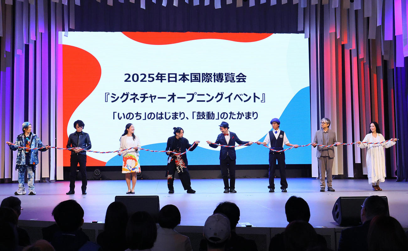 大阪・関西万博のシグネチャーオープニングイベントでロープをつなぎ「いのちをつなぐ」左から宮田裕章氏、石黒浩氏、中島ちさこ氏、落合陽一氏、福岡伸一氏、河森正治氏、小山薫堂氏、河瀬直美氏（撮影・藤尾明華）