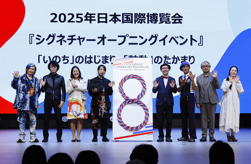 大阪・関西万博のシグネチャーオープニングイベントでポーズをとる左から宮田裕章氏、石黒浩氏、中島ちさこ氏、落合陽一氏、福岡伸一氏、河森正治氏、小山薫堂氏、河瀬直美氏(撮影・藤尾明華)
