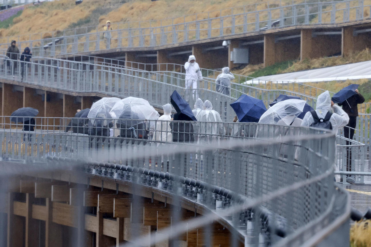 大阪・関西万博が開幕も、大荒れの天気の中、大屋根リングを歩く人たち（撮影・藤尾明華）