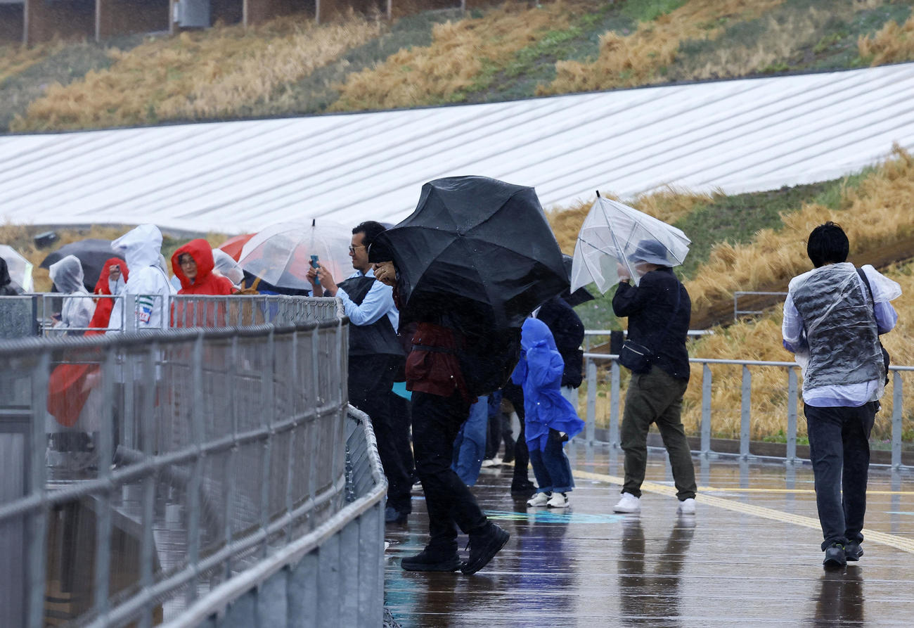 大阪・関西万博が開幕も、大荒れの天気の中、大屋根リングを歩く人たち（撮影・藤尾明華）