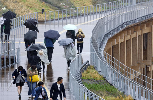 大阪・関西万博が開幕も、大荒れの天気の中、大屋根リングを歩く人たち(撮影・藤尾明華)
