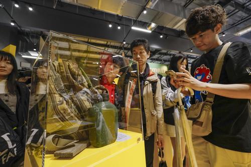 ウクライナのブースで兵士のリュックサックの展示を見る来場者(共同)