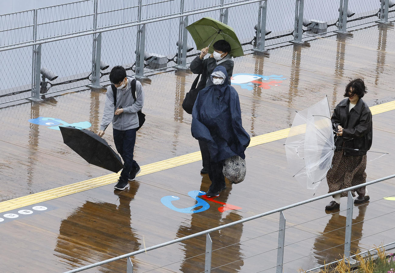 大阪・関西万博が開幕も、大荒れの天気の中、大屋根リングを歩く人たち（撮影・藤尾明華）